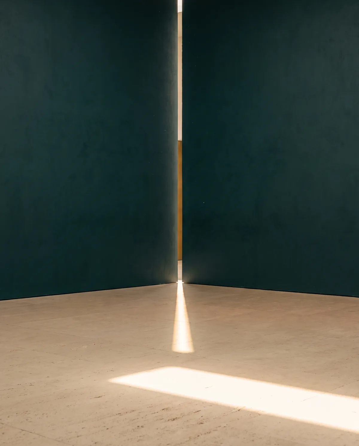 Light falling through a narrow gap between deep teal walls.
